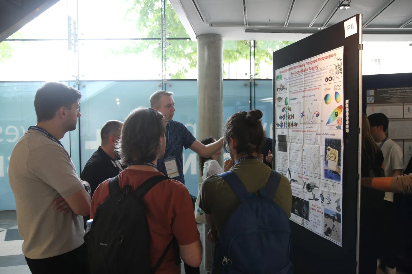 Researchers listening to a poster presentation at META 2026, Trinity College Dublin