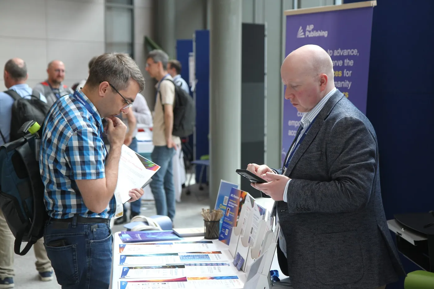 Attendees browsing journals at a publisher stand at META 2026, Trinity College Dublin